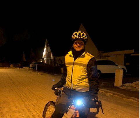 En man med reflexväst och hjälm på cykel