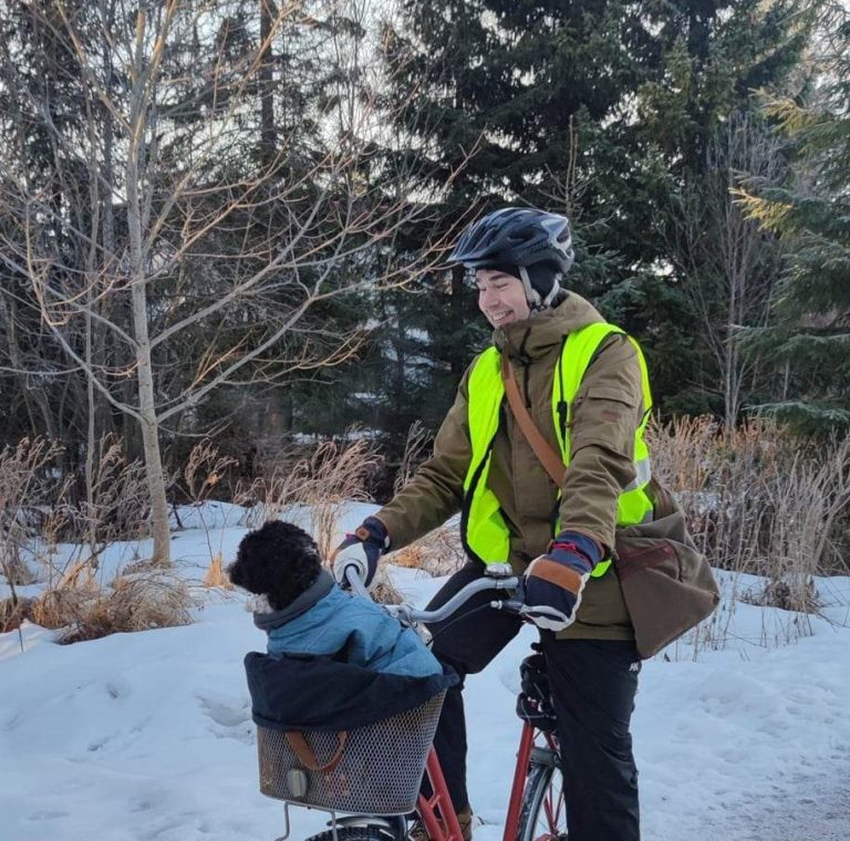 En man med reflexväst och hjälm på cykel