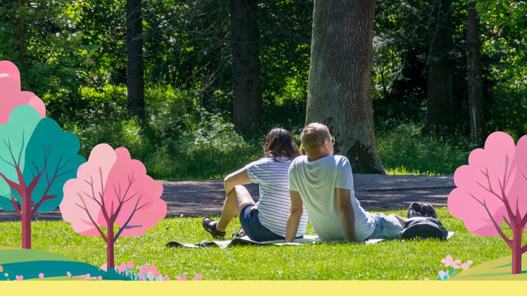 Två personer som sitter i gräset med illustrerade träd runt om