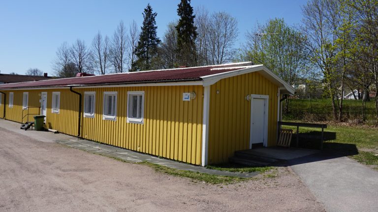 Brynäsvallens omklädningsrum och café. Ingång på kortsidan utan tröskel eller nivåskillnad. Ingången på långsidan saknar ramp.