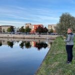 En person står och fiskar ner i en å