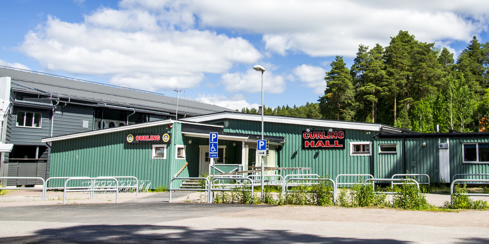 Ett gröns hus. Blå himmel med vita moln