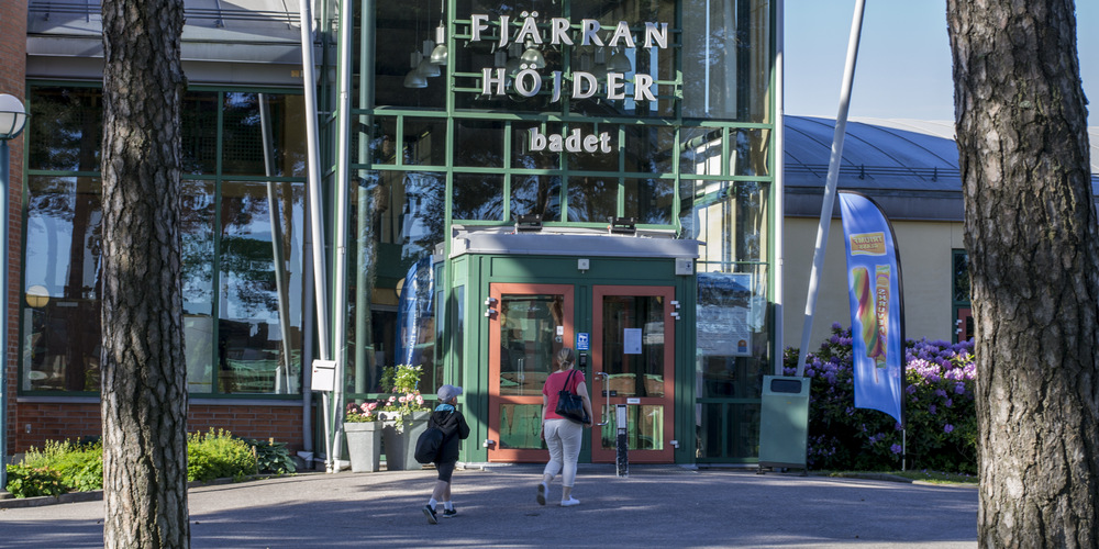 Entre till fjärran höjderbadet. Två personer går utanför