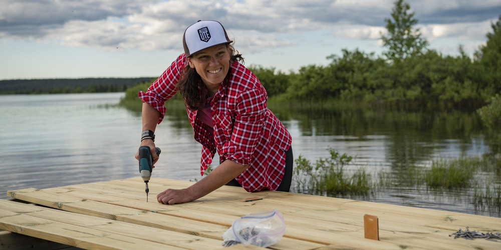 En kvinna skruvar med en maskin.