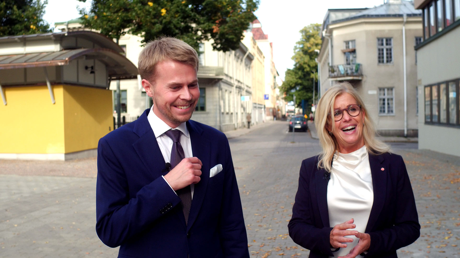 William Elofsson (M) och Åsa Wiklund Lång (S) skrattar tillsammans efter ett kommunstyrelsesammanträde.