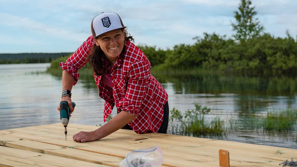 Kvinna som bygger en altan vid vattnet