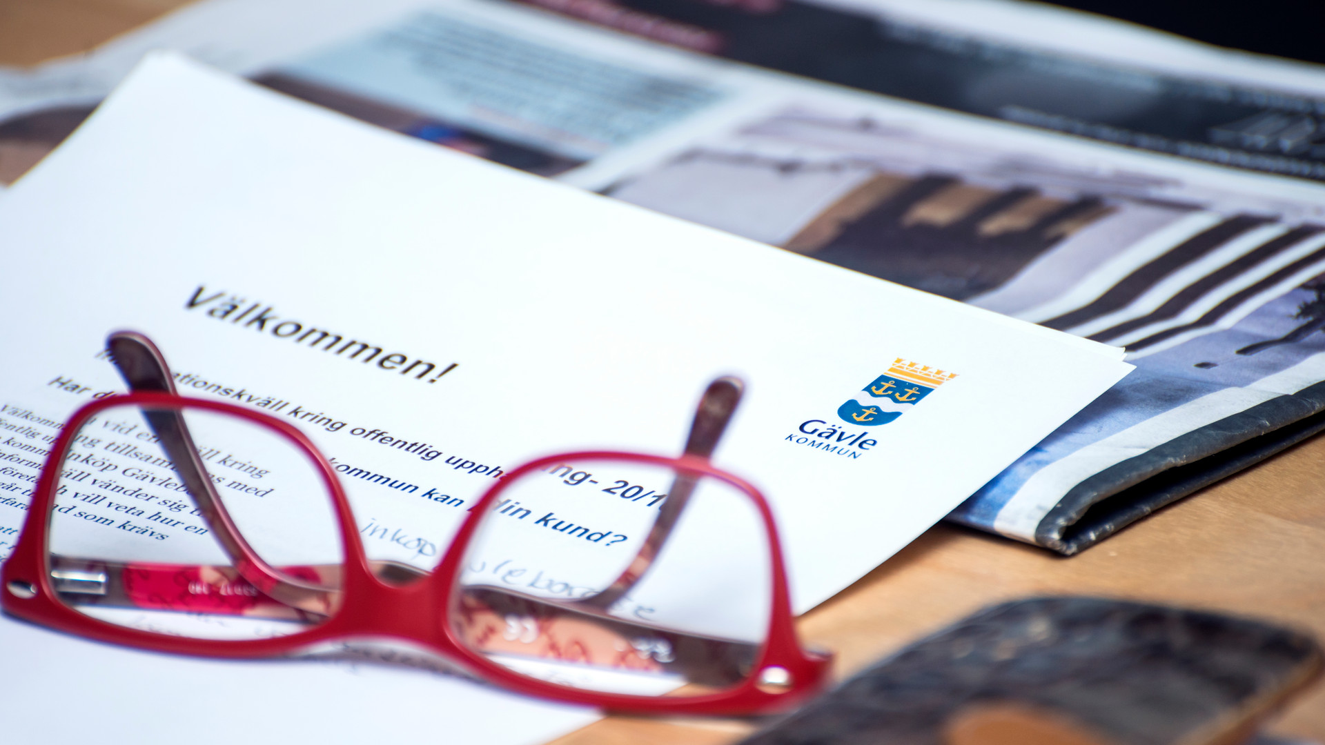 Ett par glasögon som ligger på ett papper med text på samt Gävle kommuns logo
