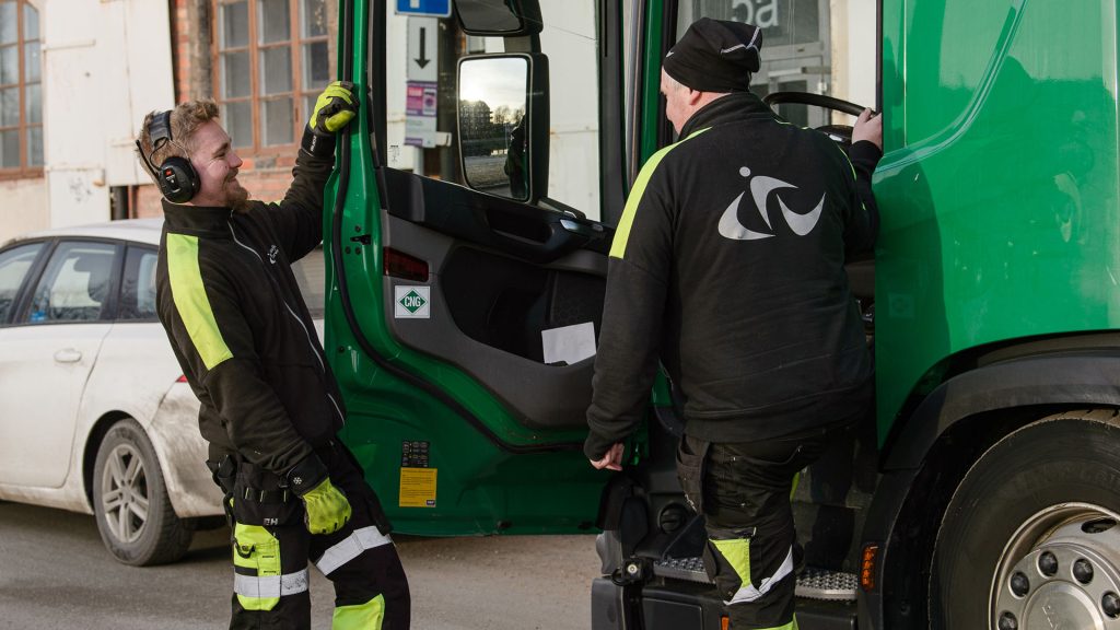 Medarbetare på Gästrike återvinnare som står vid en sopbil