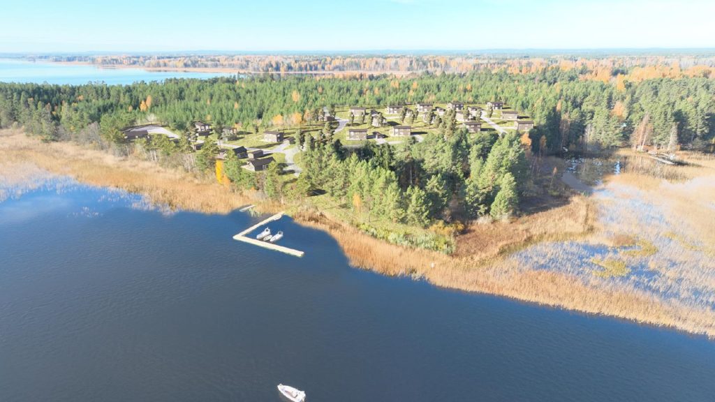 En flygbild över sjö och land med träd och hus