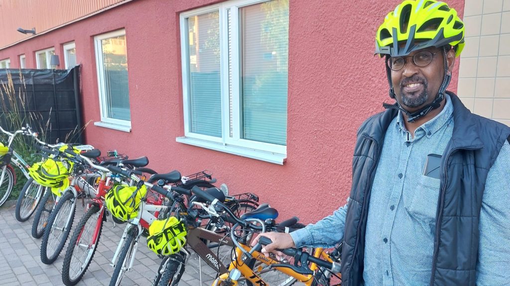Man som står vid cyklar
