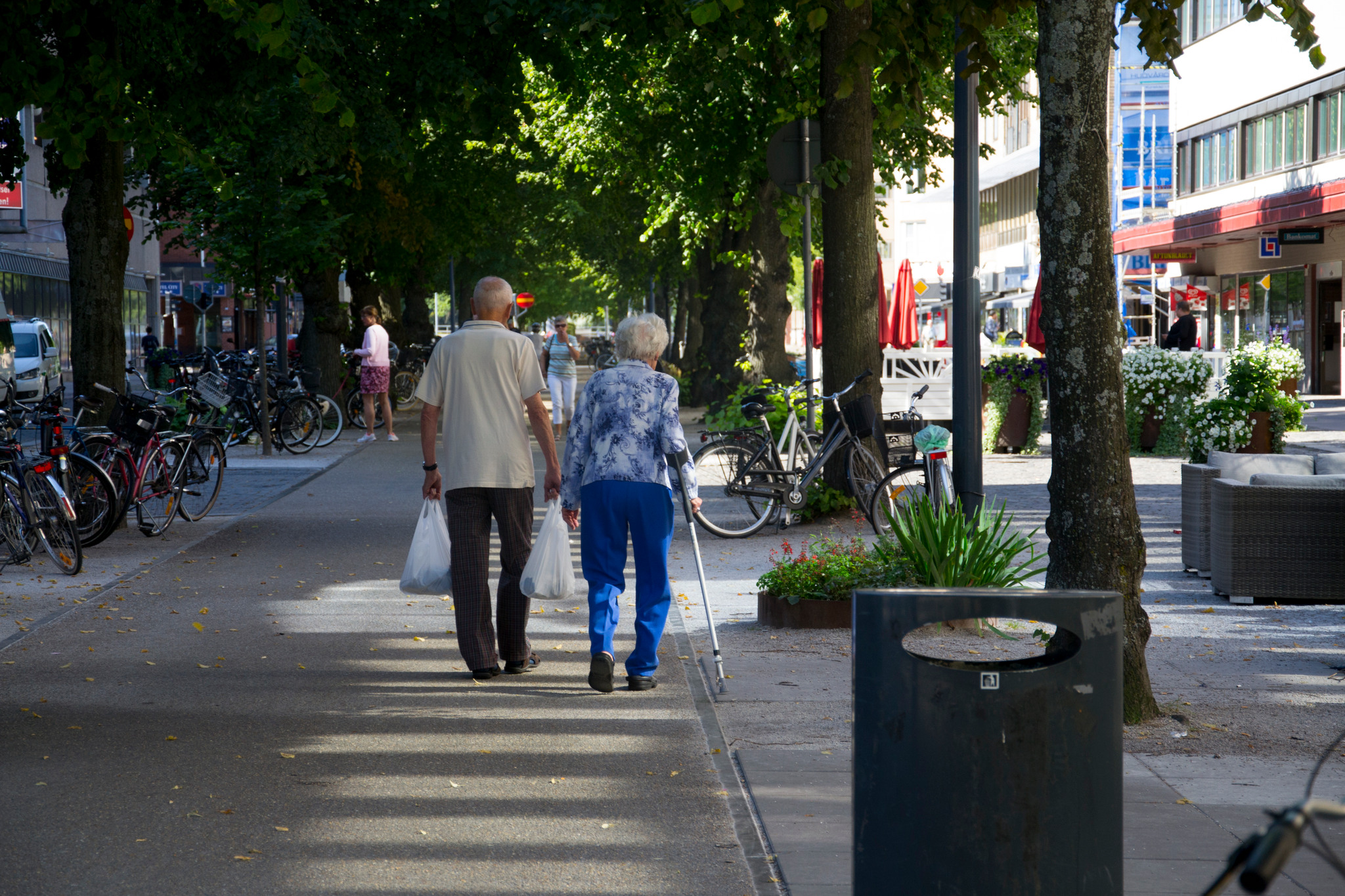 Två äldre personer som går på en gångbana i Gävle centrum.