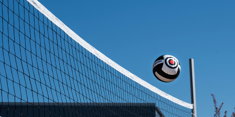 Volleyboll som flyger över ett nät