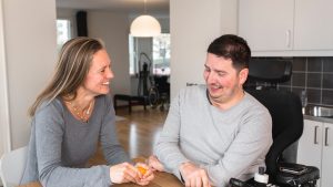 Två personer sitter och umgås vid ett köksbord.