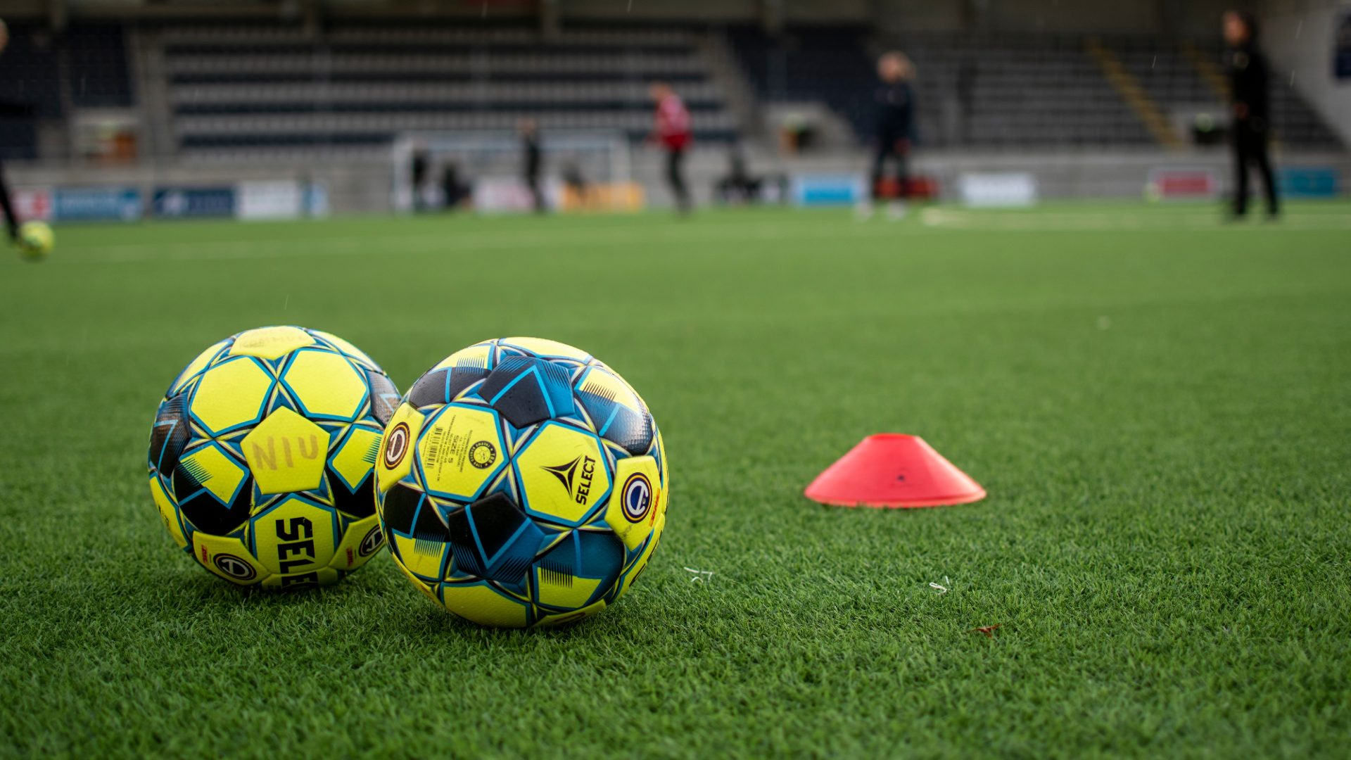 Två fotbollar på en plan.
