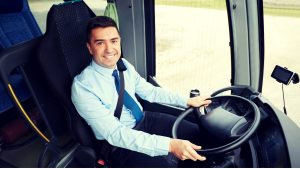 Busschaufför vid ratten.