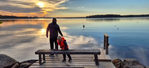 Två personer som står på en brygga och fiskar