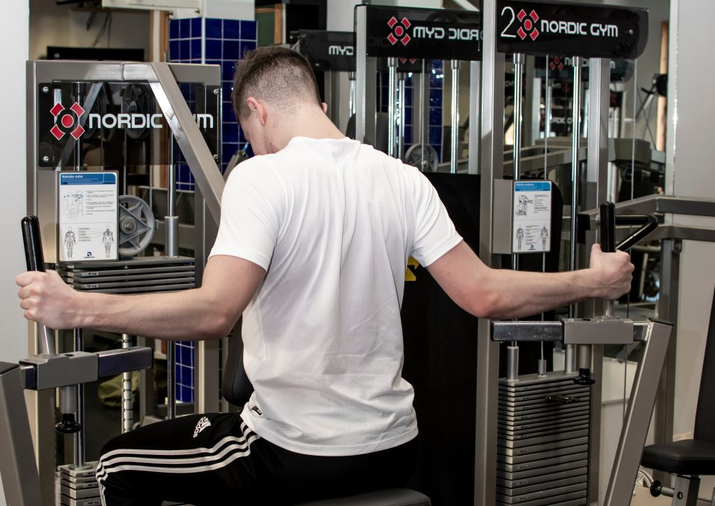 Kille som tränar armar på gym