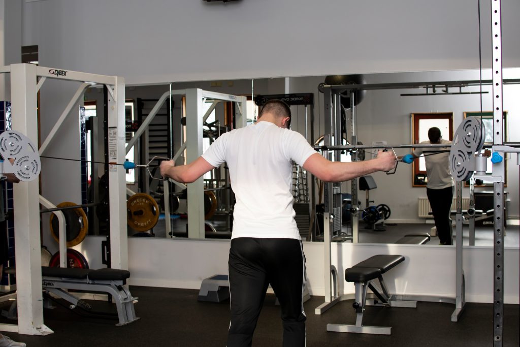 Kille som tränar armar på gym