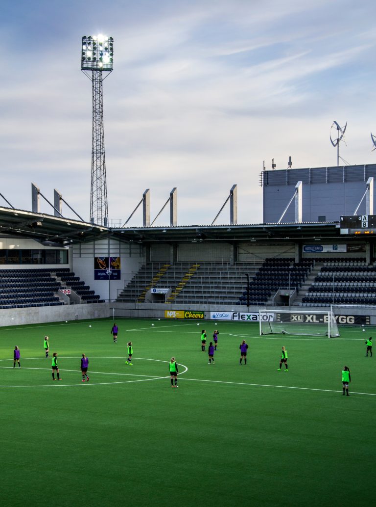 Fotbollsspelare i västar på gräsplanen på Gavlevallen