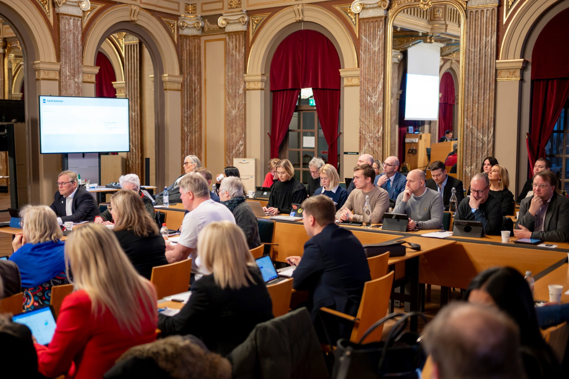 Personer som sitter vid bord i en stor sal.