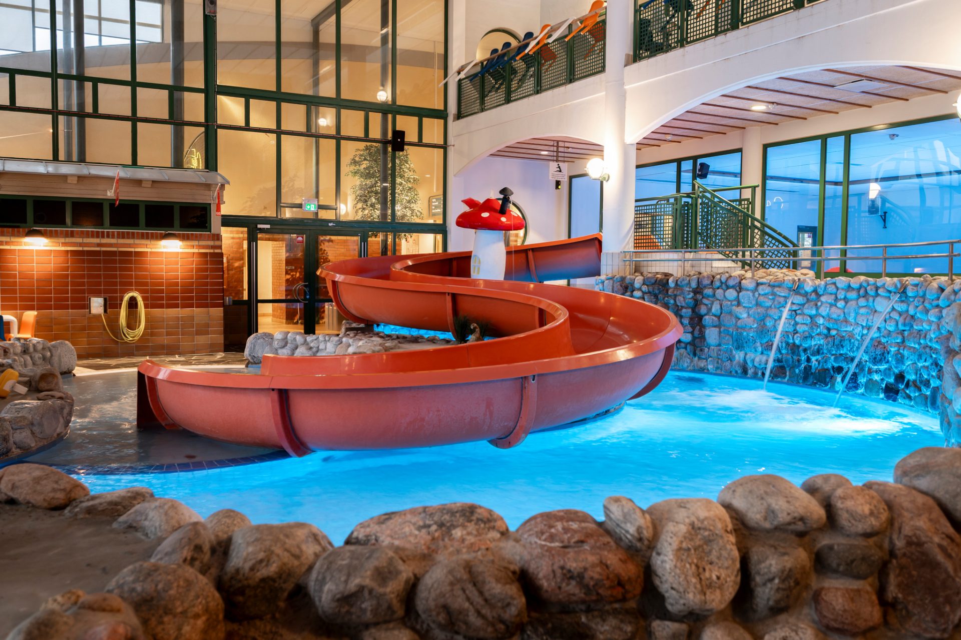 Vy över vattenrutschkana och pool i inomhusbadet