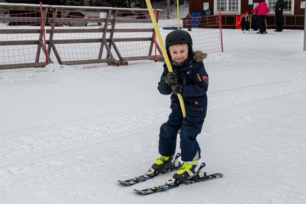 Liten pojke som åker skidor