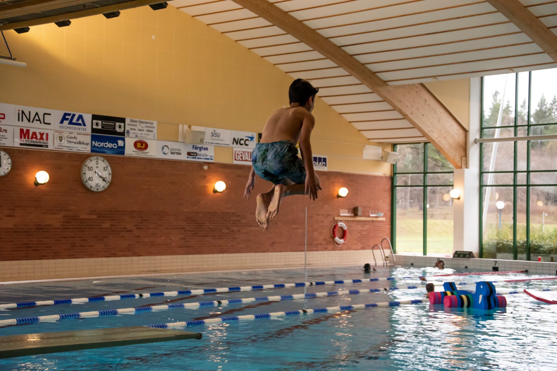 barn som hoppar från trampolin ner i en pool