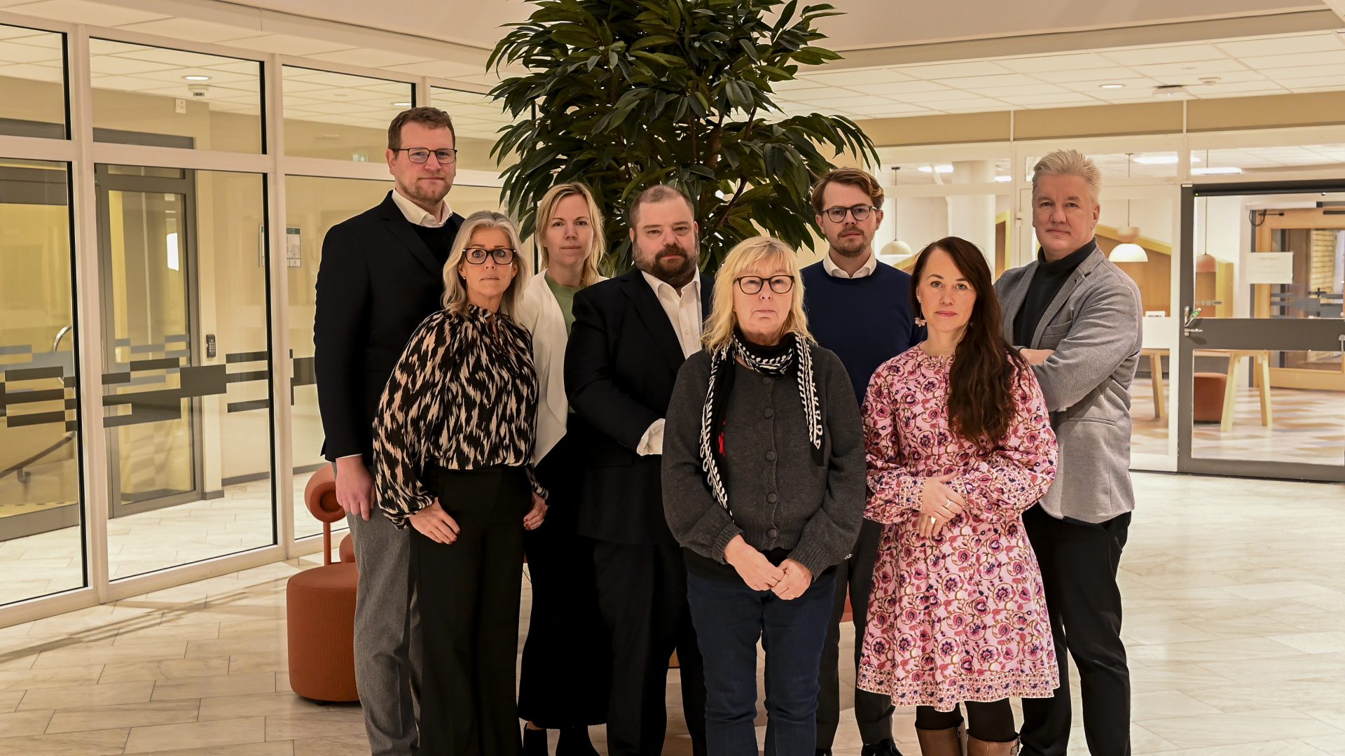 Personer som står och blir fotograferade i en lokal.