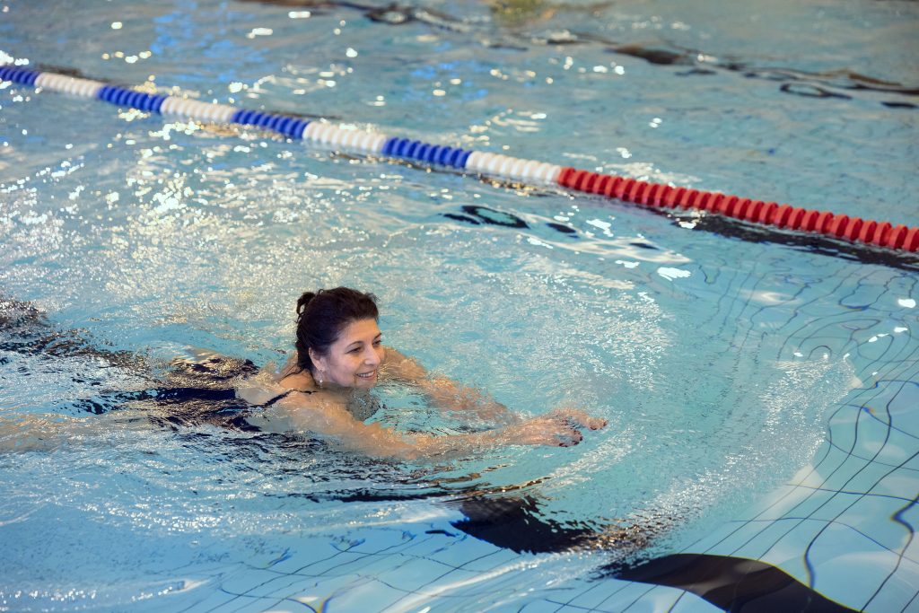 Kvinna som motionssimmar i en bassäng