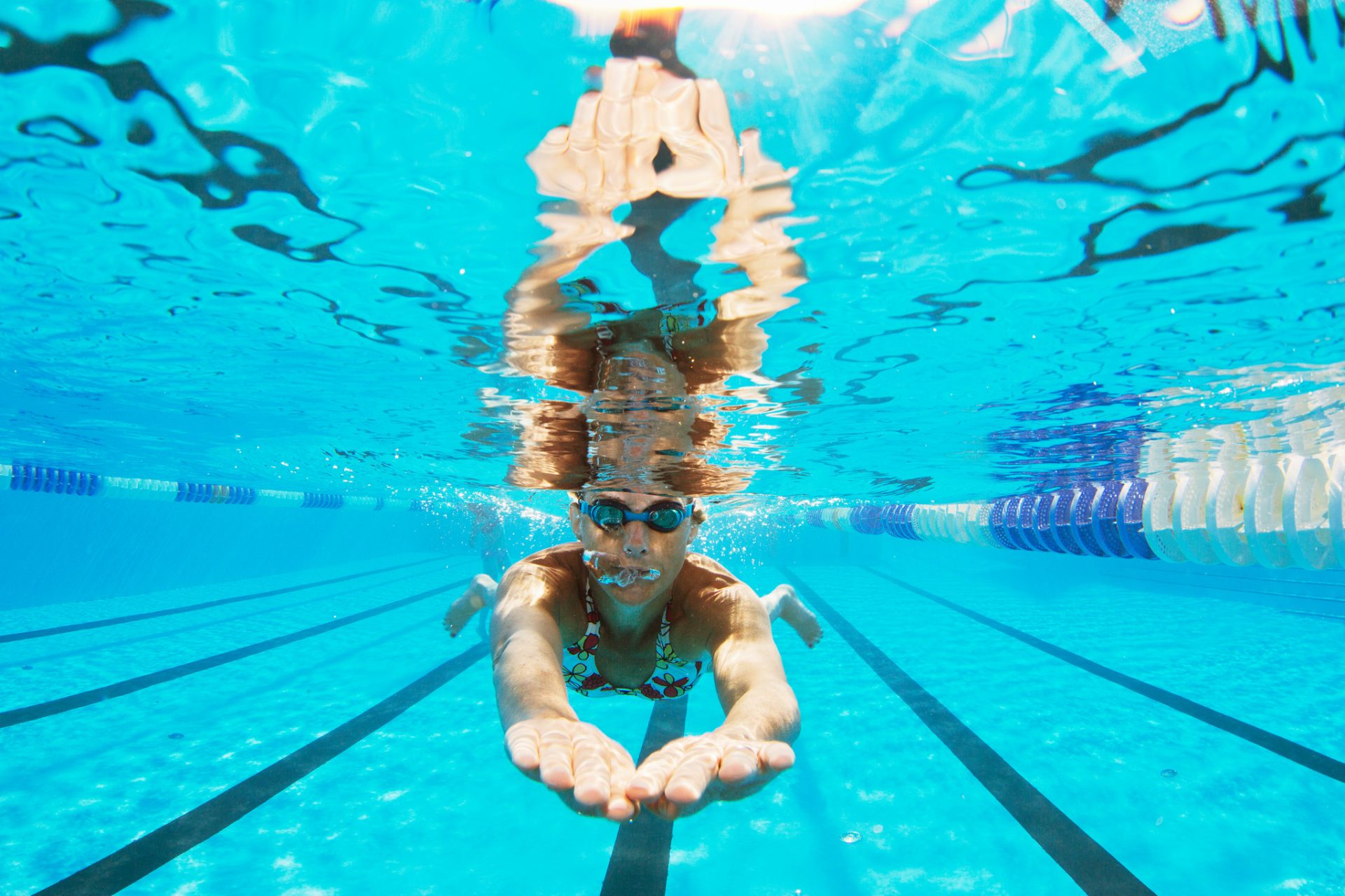 Kvinna som motionssimmar i en bassäng