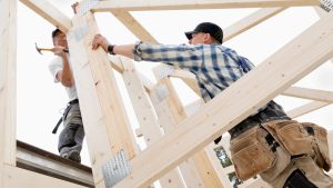 Två killar som snickrar utomhus.