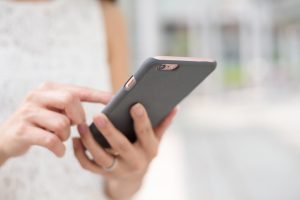 Person som håller i en mobiltelefon.