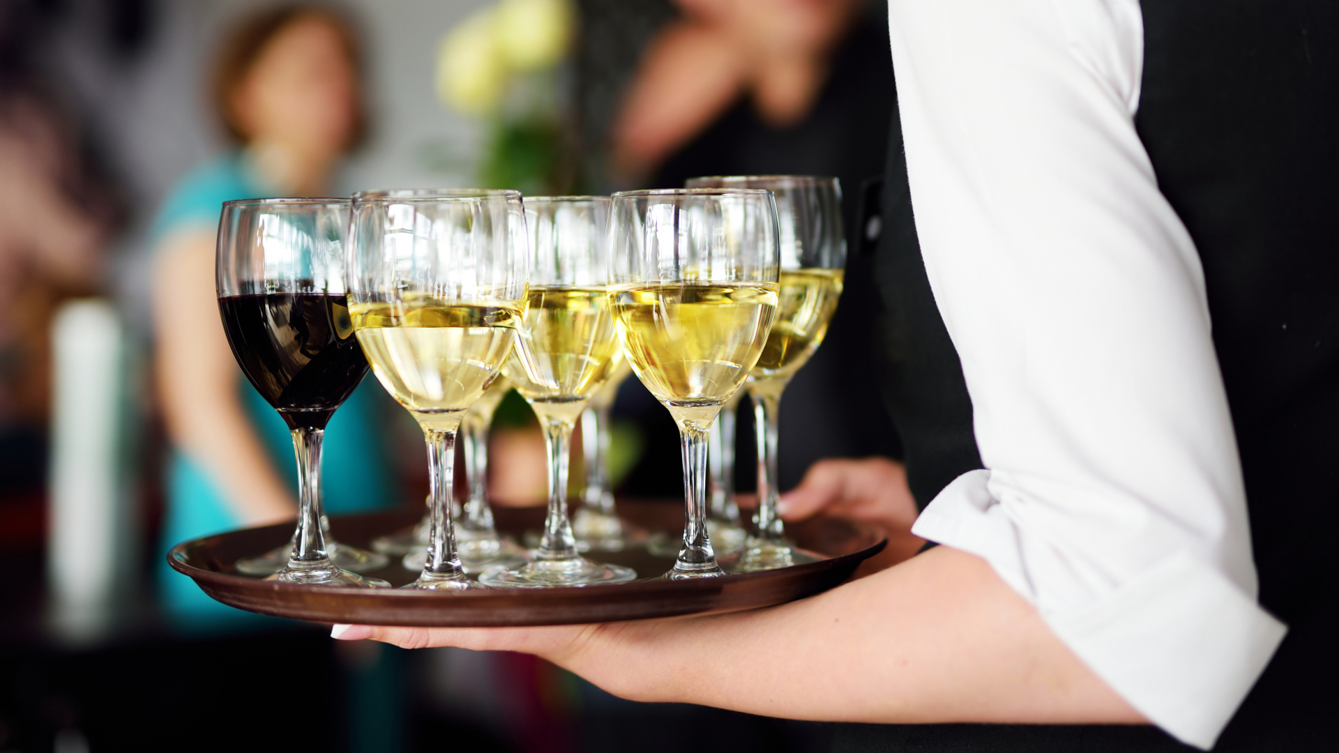serveringspersonal med en bricka med flera glas