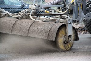 En traktor som sopar upp sand från gata