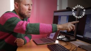 En man pekar mot en datorskärm