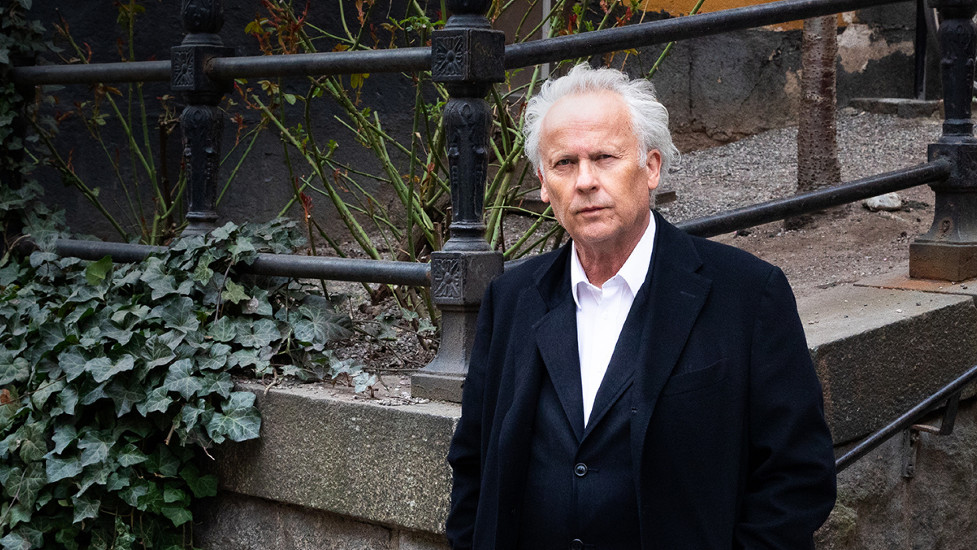 En man i rock framför en trapp