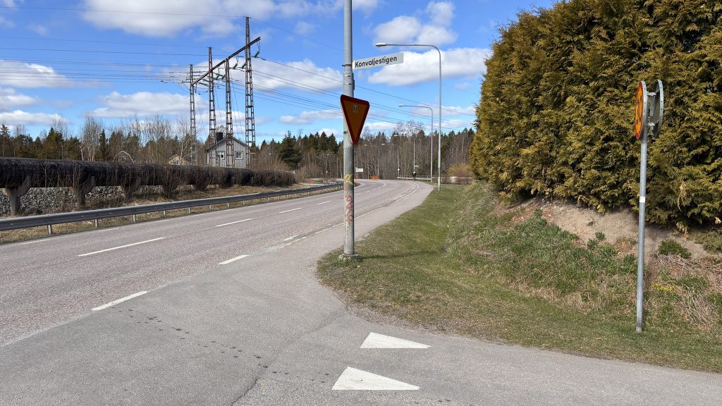 Vägkorsning vid Konvaljestigen. Tågledningar i bakgrunden. 