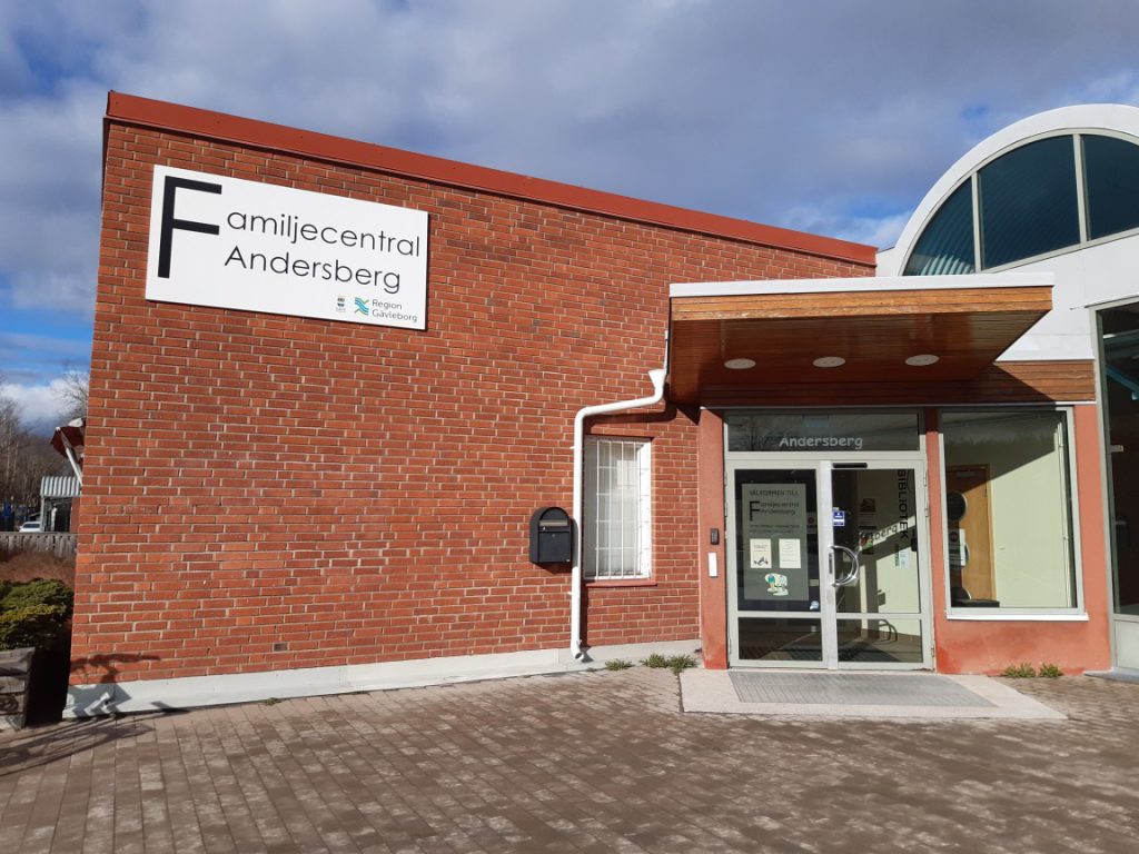 Tegelbyggnad med ingång och skylt på Andersbergs familjecentral.