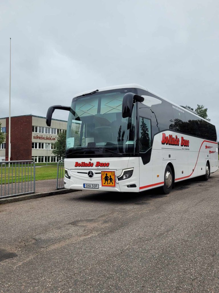 Bild på en skolbuss utanför en skola.