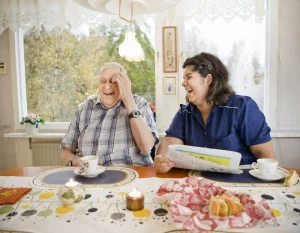 Två personer som sitter vid ett bord och läser tidning.