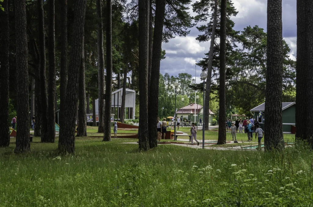 Människor i park och spelar minigolf.