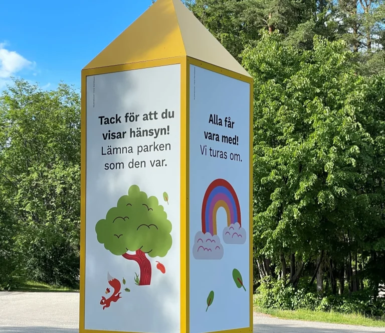 Stolpe med text i lekpark.