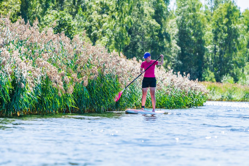 Kvinna paddlar på sup bräda