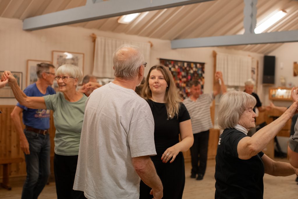 En grupp personer i olika åldrar dansar.