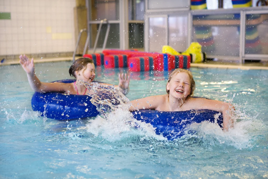 två barn som leker i en pool.
