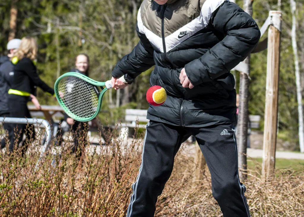 En som kör tennis på hösten.